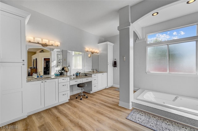 bathroom with vanity, ornate columns, hardwood / wood-style flooring, and a washtub