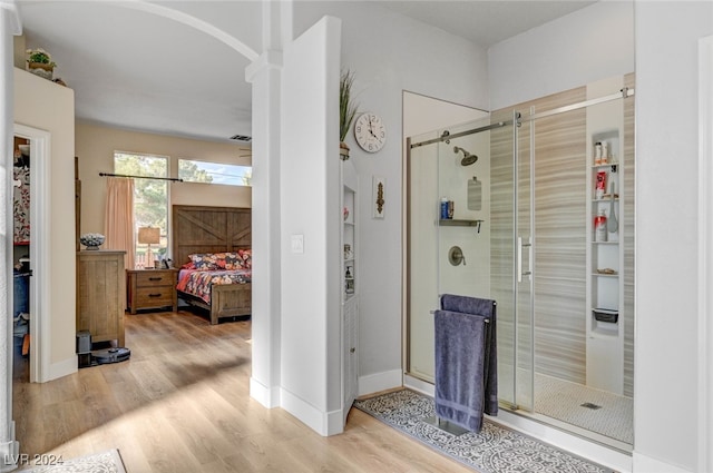 bathroom with a shower with door and hardwood / wood-style floors