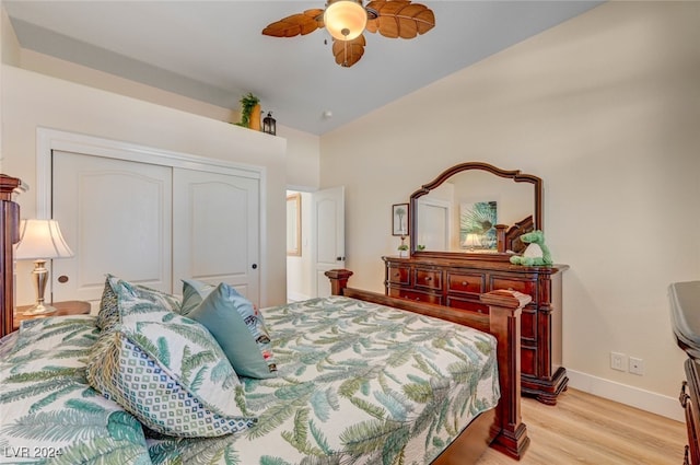 bedroom featuring lofted ceiling, a closet, light hardwood / wood-style floors, and ceiling fan