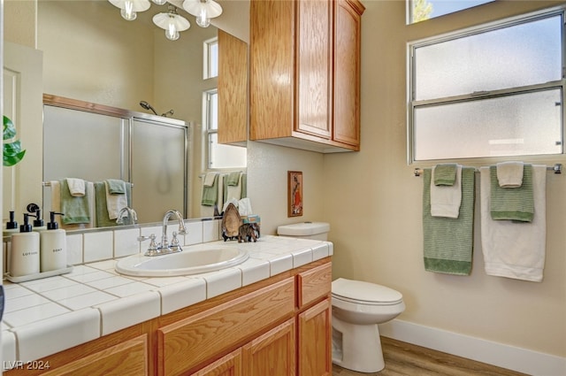 bathroom with a shower with door, vanity, toilet, and wood-type flooring