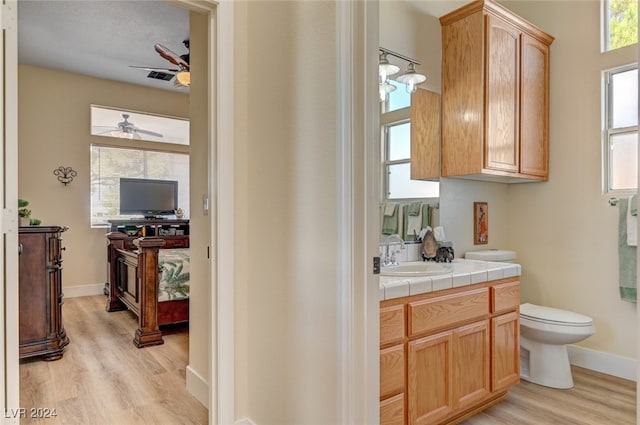 bathroom with vanity, toilet, hardwood / wood-style flooring, and ceiling fan