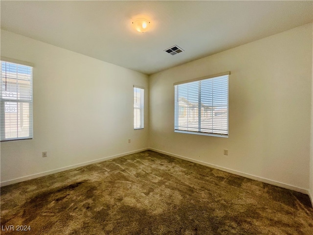 spare room featuring dark colored carpet