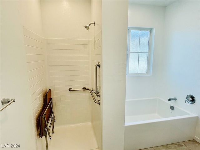 bathroom featuring tile patterned flooring and a tub to relax in