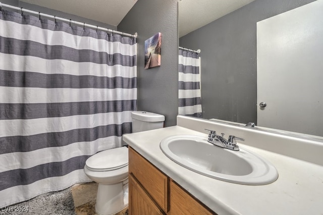 bathroom featuring toilet, a textured ceiling, and vanity