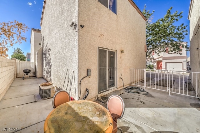 rear view of property featuring a garage and a patio