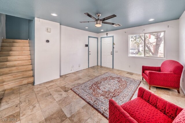 living area featuring a textured ceiling and ceiling fan