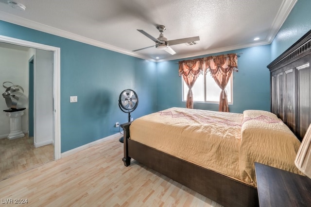 bedroom featuring a closet, crown molding, a textured ceiling, light hardwood / wood-style floors, and ceiling fan