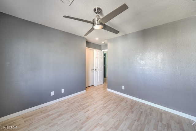 empty room with light hardwood / wood-style flooring, a textured ceiling, and ceiling fan