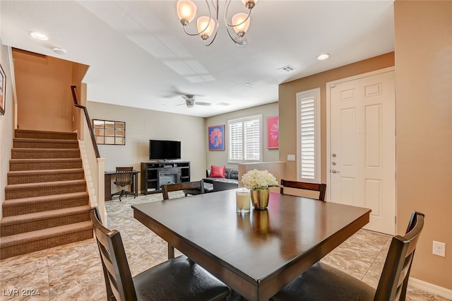 dining area with ceiling fan with notable chandelier