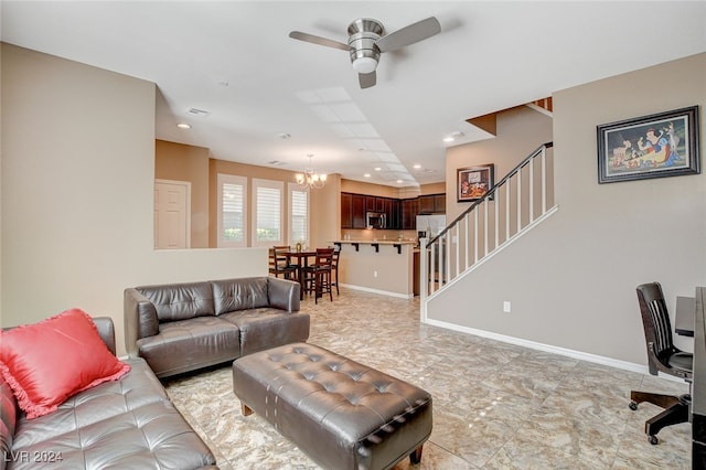 living room featuring ceiling fan with notable chandelier