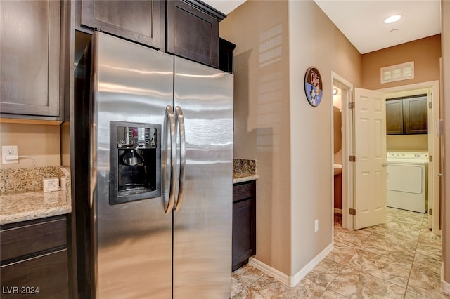 kitchen with light stone countertops, dark brown cabinets, and stainless steel refrigerator with ice dispenser