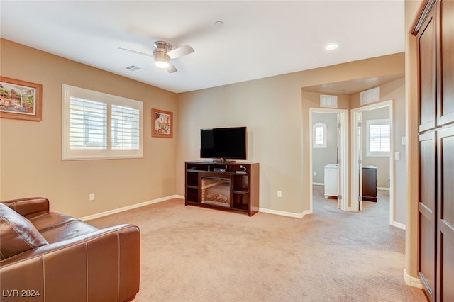 carpeted living room with ceiling fan