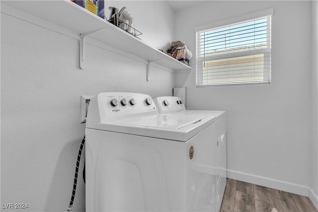 laundry area with light hardwood / wood-style flooring and washing machine and clothes dryer