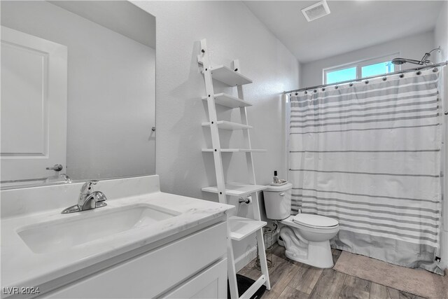 bathroom featuring vanity, hardwood / wood-style floors, curtained shower, and toilet