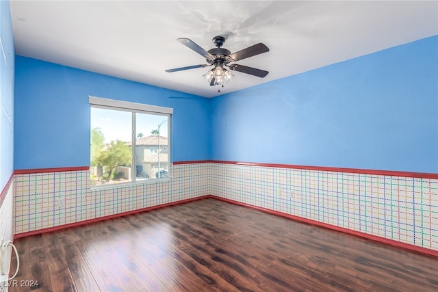 empty room with ceiling fan and dark wood-type flooring