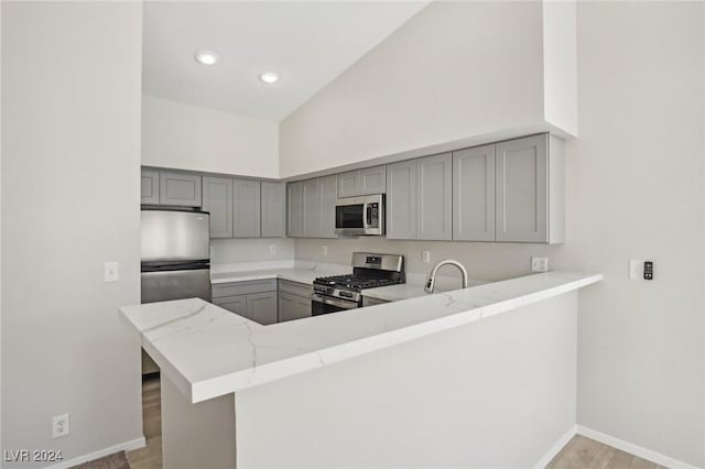 4811 Black Bear Rd Unit 201, Las Vegas, NV 89149 - kitchen featuring appliances with stainless steel finishes, gray cabinets, baseboards, light stone countertops, and recessed lighting