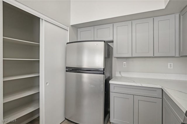 4811 Black Bear Rd Unit 201, Las Vegas, NV 89149 - kitchen with freestanding refrigerator, gray cabinets, and light stone countertops