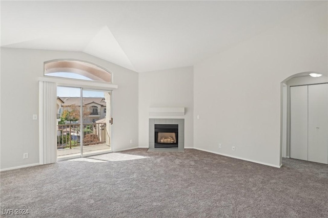 4811 Black Bear Rd Unit 201, Las Vegas, NV 89149 - unfurnished living room with carpet, lofted ceiling, a tile fireplace, baseboards, and arched walkways