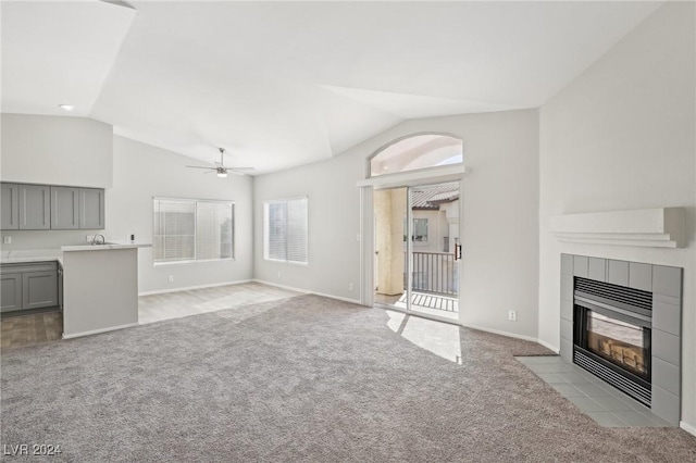 4811 Black Bear Rd Unit 201, Las Vegas, NV 89149 - unfurnished living room with vaulted ceiling, light carpet, a fireplace, ceiling fan, and baseboards