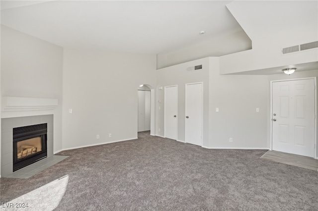 unfurnished living room featuring carpet floors and a tile fireplace