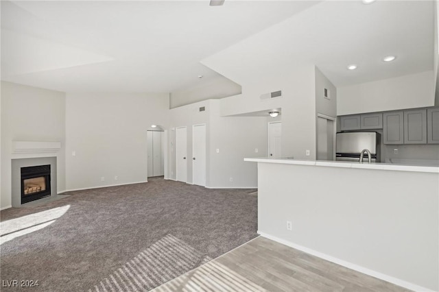 4811 Black Bear Rd Unit 201, Las Vegas, NV 89149 - unfurnished living room featuring a fireplace with flush hearth, baseboards, recessed lighting, light carpet, and a sink