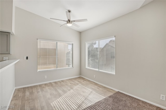 spare room with lofted ceiling, light wood-type flooring, and ceiling fan