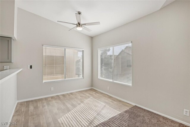 4811 Black Bear Rd Unit 201, Las Vegas, NV 89149 - empty room with a ceiling fan, vaulted ceiling, light wood-type flooring, and baseboards