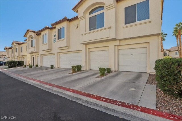 4811 Black Bear Rd Unit 201, Las Vegas, NV 89149 - view of front of property with stucco siding, an attached garage, driveway, and a residential view