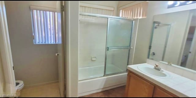 full bathroom with vanity, toilet, and bath / shower combo with glass door