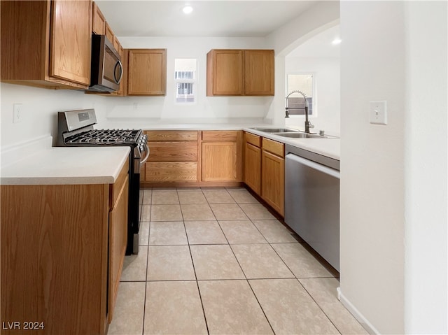 kitchen with light tile patterned floors, appliances with stainless steel finishes, and sink