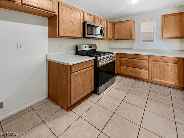 kitchen with appliances with stainless steel finishes and light tile patterned floors