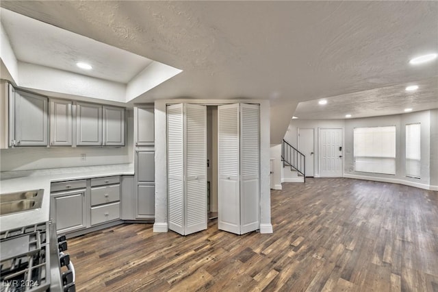 kitchen featuring a textured ceiling, gray cabinetry, and dark hardwood / wood-style floors