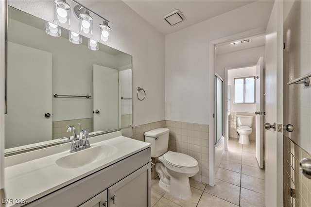 full bathroom featuring tile patterned floors, vanity, toilet, and tile walls