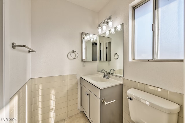 bathroom with tile patterned flooring, vanity, tile walls, and toilet