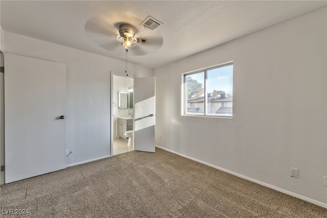 unfurnished room with a textured ceiling, carpet floors, and ceiling fan