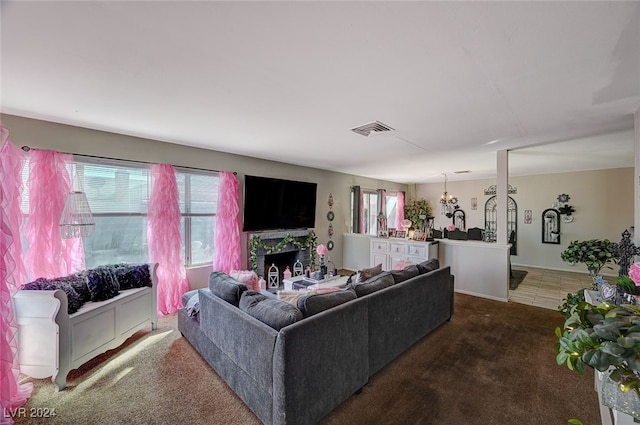 living room with dark colored carpet and an inviting chandelier