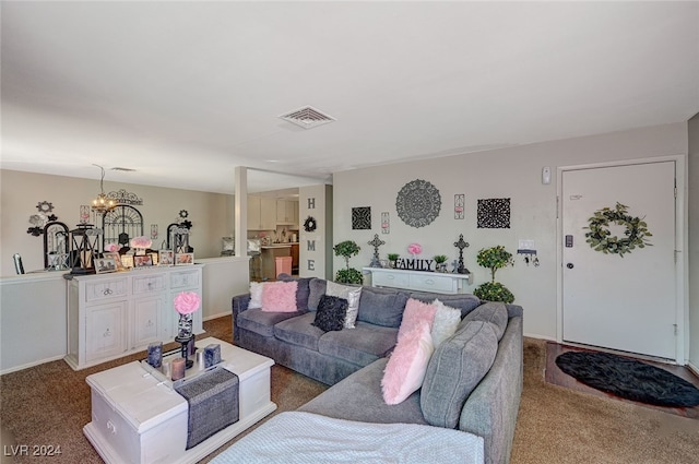 carpeted living room featuring a chandelier