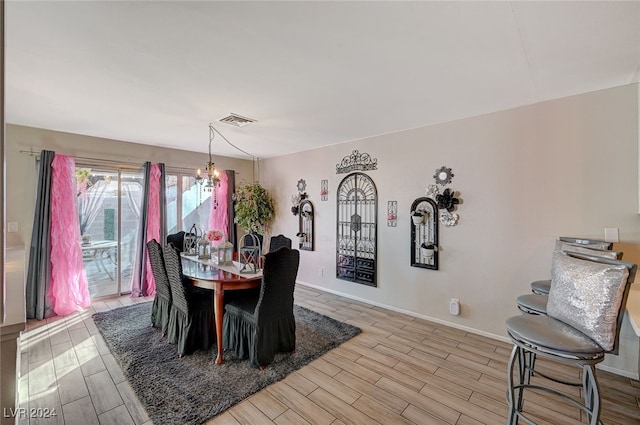 dining area featuring light hardwood / wood-style floors and a chandelier