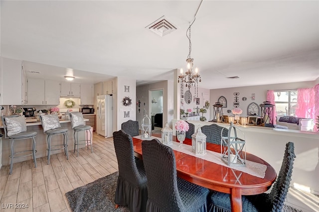 dining space featuring a notable chandelier and light hardwood / wood-style flooring