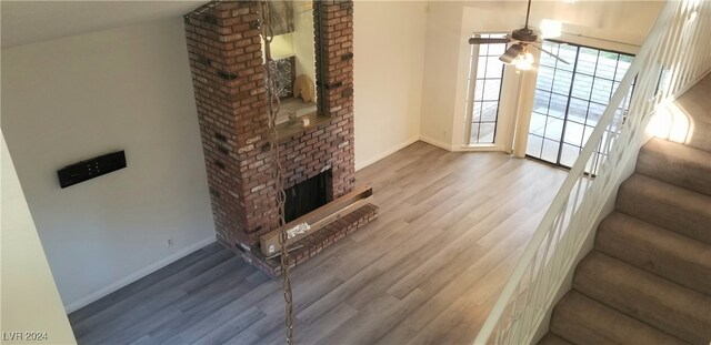 living room featuring a fireplace, ceiling fan, hardwood / wood-style floors, and lofted ceiling