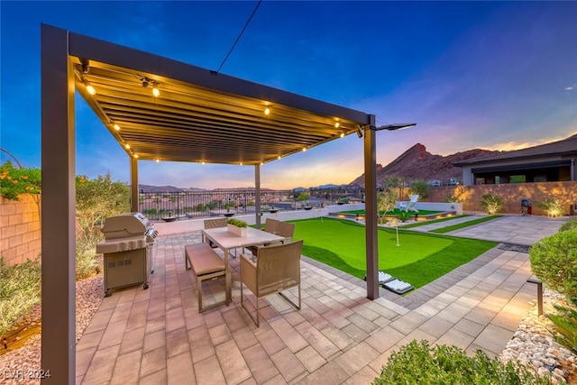 patio terrace at dusk with a mountain view and a grill