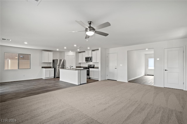 unfurnished living room featuring dark wood-type flooring, ceiling fan, and sink