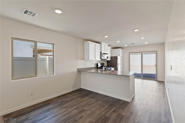 kitchen with white cabinetry, kitchen peninsula, stainless steel appliances, and dark hardwood / wood-style floors