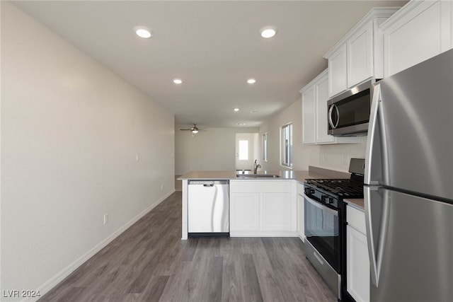 kitchen featuring appliances with stainless steel finishes, sink, kitchen peninsula, and white cabinets