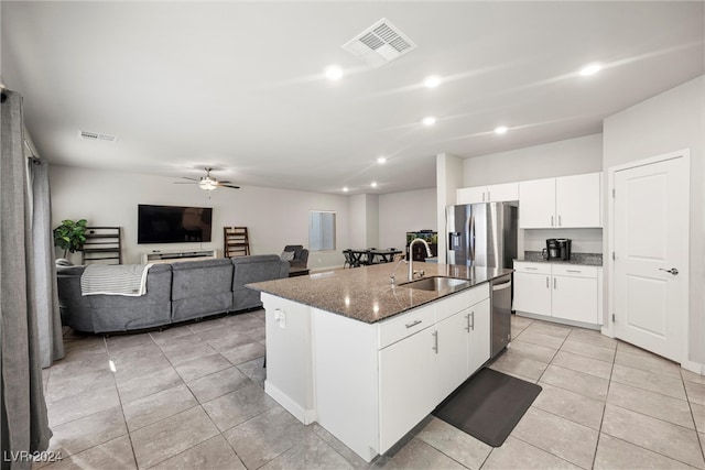 kitchen with sink, an island with sink, ceiling fan, stainless steel appliances, and white cabinets