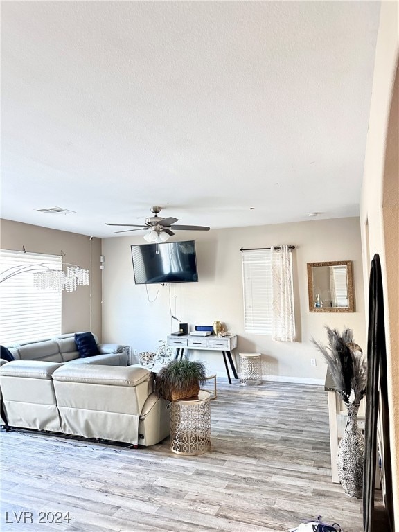 living room featuring a healthy amount of sunlight, light wood-type flooring, and ceiling fan