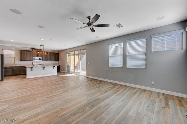 unfurnished living room featuring light hardwood / wood-style floors and ceiling fan