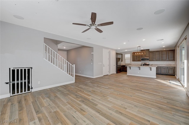 unfurnished living room with light hardwood / wood-style floors and ceiling fan