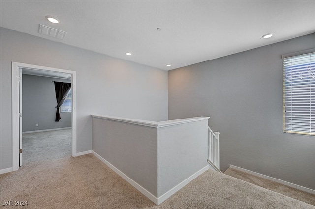 hallway featuring light colored carpet