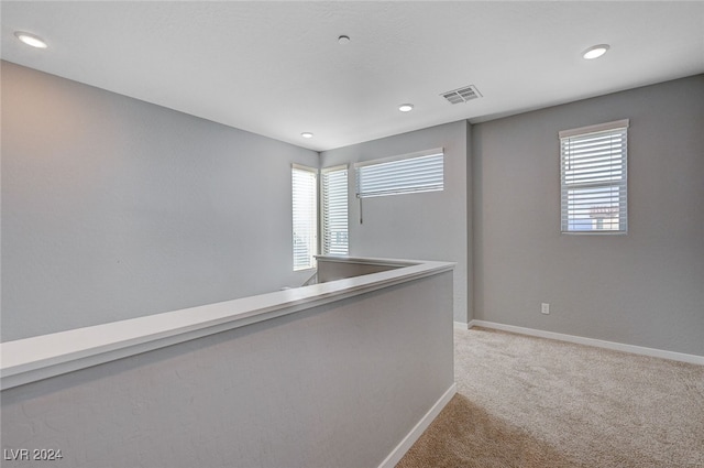 hall with light colored carpet